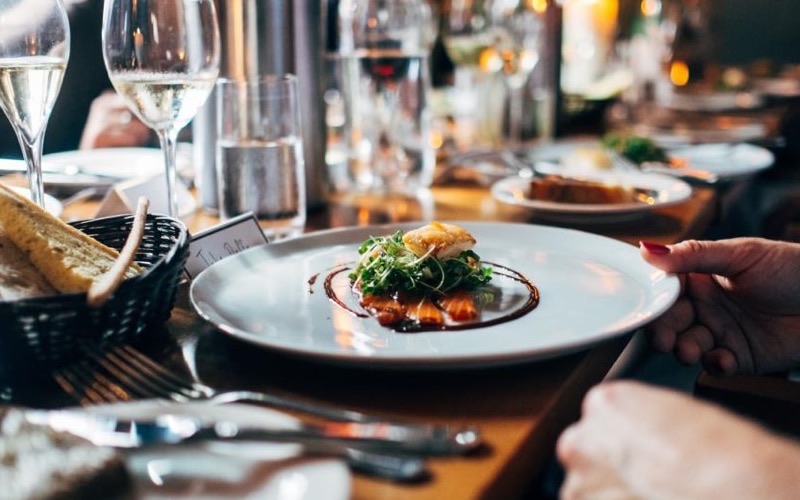 A plated dinner with a glass of wine at a restaurant